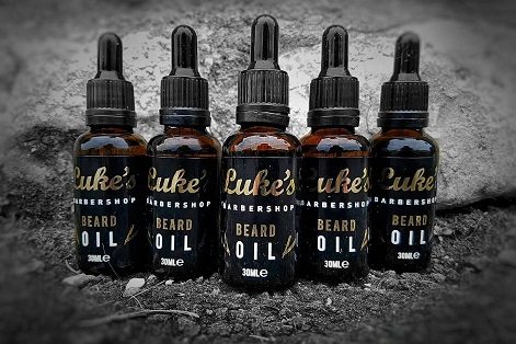 A row of Luke's Barbershop beard oil bottles.